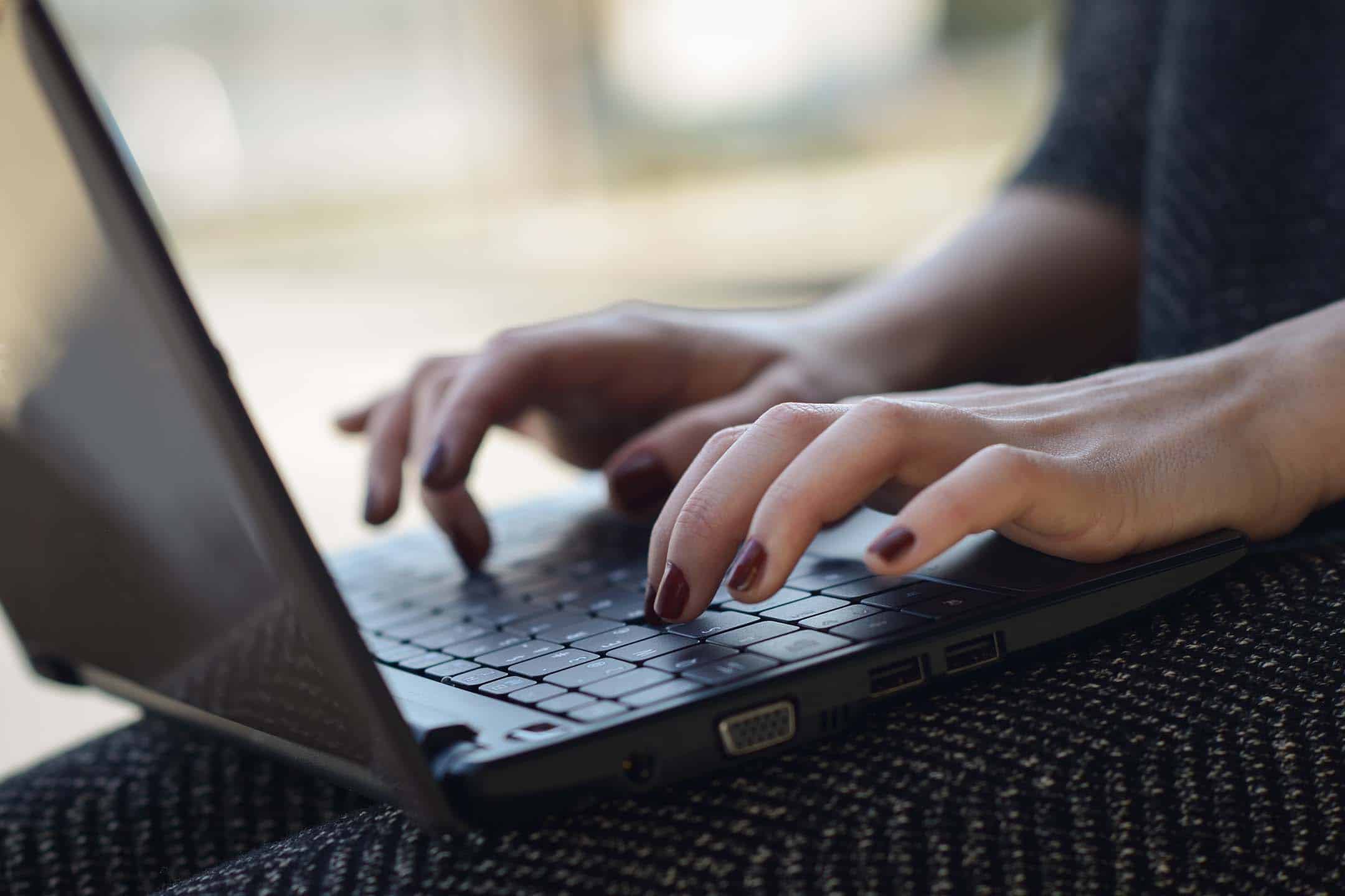 Kvindehænder, der skriver på en bærbar computer