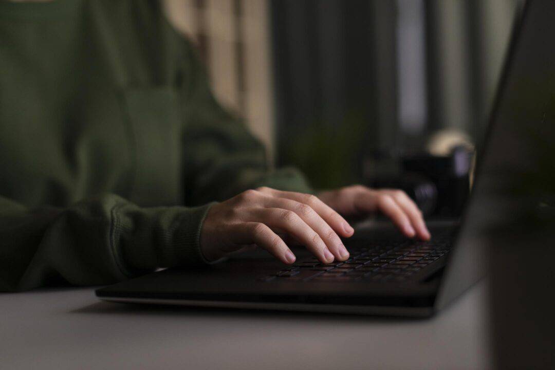 A woman typing on her laptop