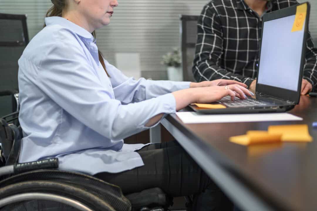 A wheelchair user using a laptop