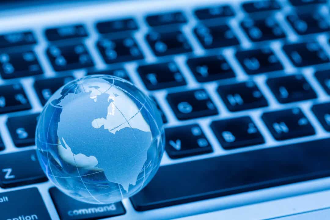 World globe and computer keyboard dark blue background