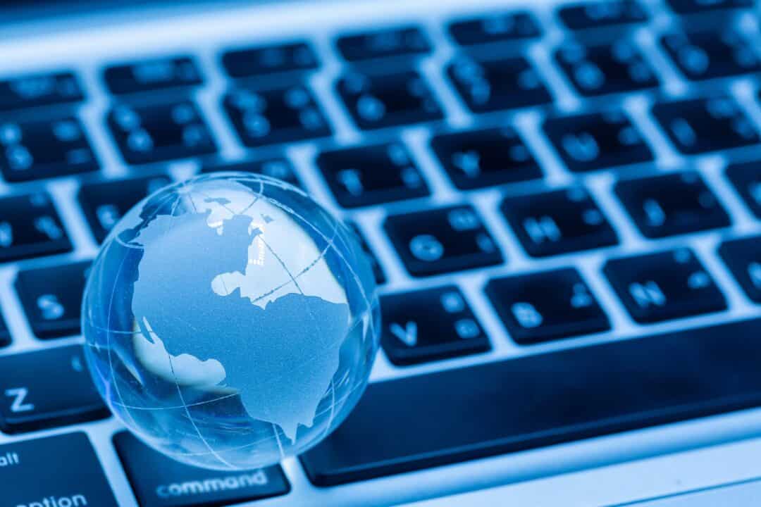 Globe terrestre et clavier d'ordinateur sur fond bleu foncé